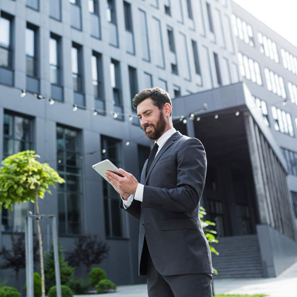 Property manager con tablet in atrio uffici, dashboard di ticketing e KPI immobiliari